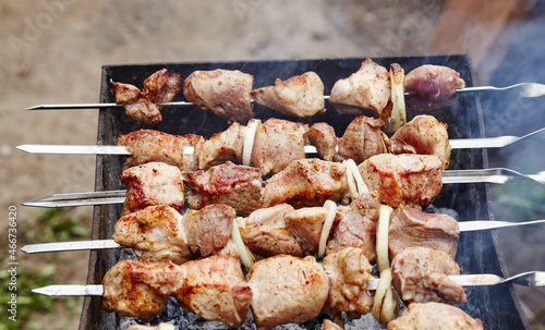 Marinated shashlik preparing on a barbecue grill over charcoal. Traditional Russian shashlik on a barbecue skewer