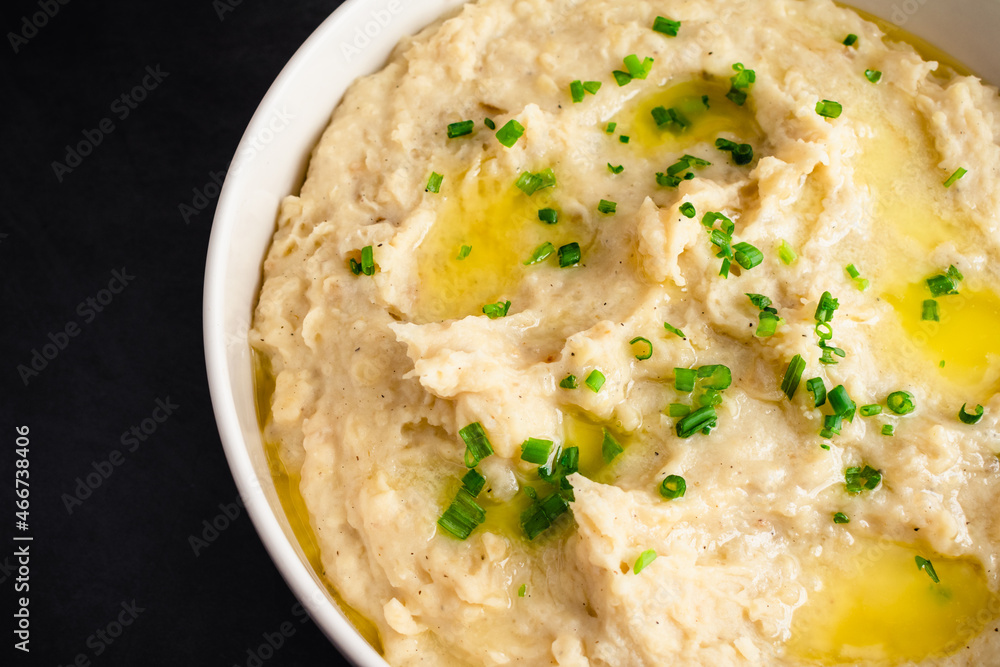 Garlic Mashed Potatoes in a Serving Bowl: A large bowl of whipped potatoes topped with chives and melted butter Garlic Mashed Potatoes in a Serving Bowl: A large bowl of whipped potatoes topped with chives and melted butter