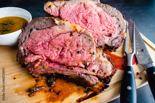 Fotografie Slices of Medium Rare Bone-in Prime Rib with Au Jus: Carved standing prime rib r