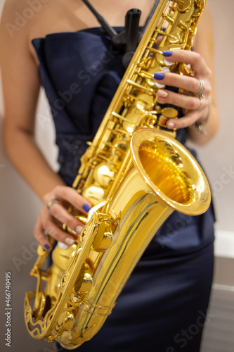 Photography Young woman jazz musician playing the saxophone, closeup image.