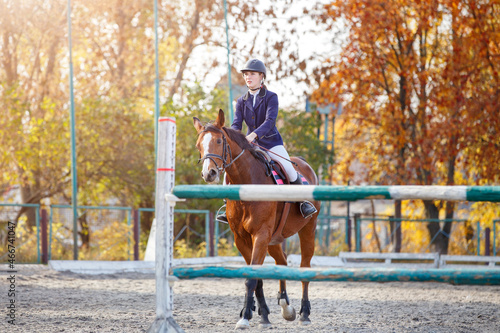 Young teenage girl riding horse before her show jumping test in equestrian competition