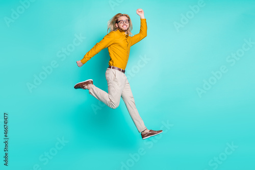 Fototapeta Naklejka Na Ścianę i Meble -  Full body profile side photo of young guy happy positive smile have fun jump go walk run isolated over turquoise color background