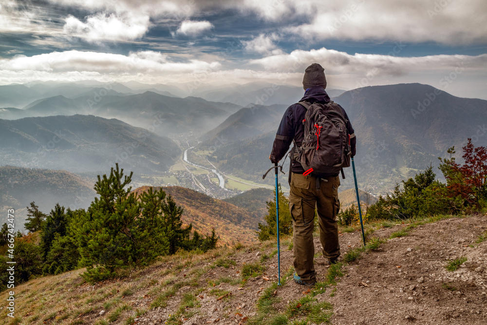 Hiker with trekking poles looking from top of the hill Sip in Slovakia Hiker with trekking poles looking from top of the hill Sip in Slovakia