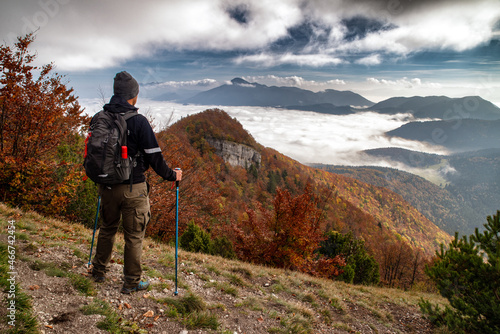 Hiker with trekking poles looking from top of the hill Sip in Slovakia