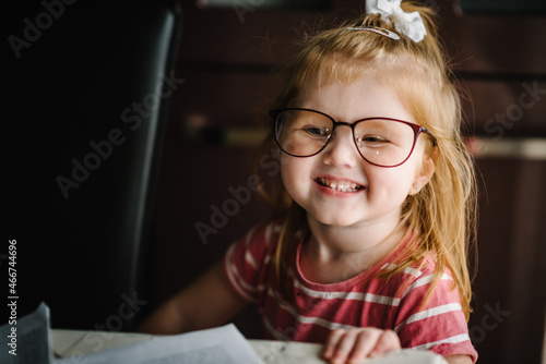 Funny girl in glasses. Happy small blonde child happy in brand new glasses.