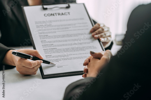 close up of business people or lawyers discussing and signing a contract or business agreement at law firm office, business people discuss document legal, law, and justice advice service concept.