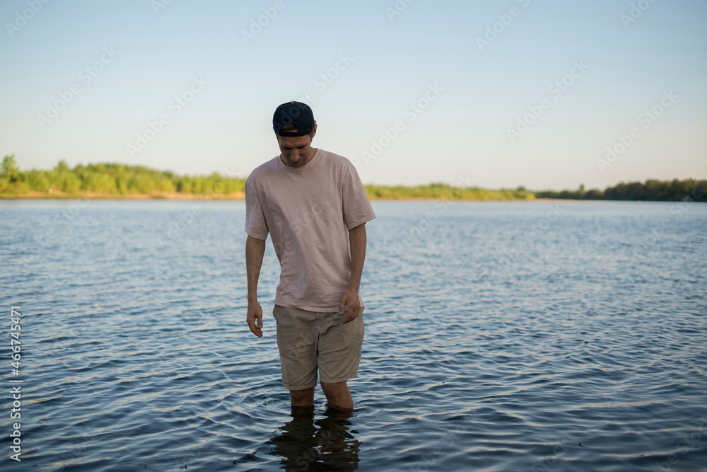 man standing in the water on a beach on summer season