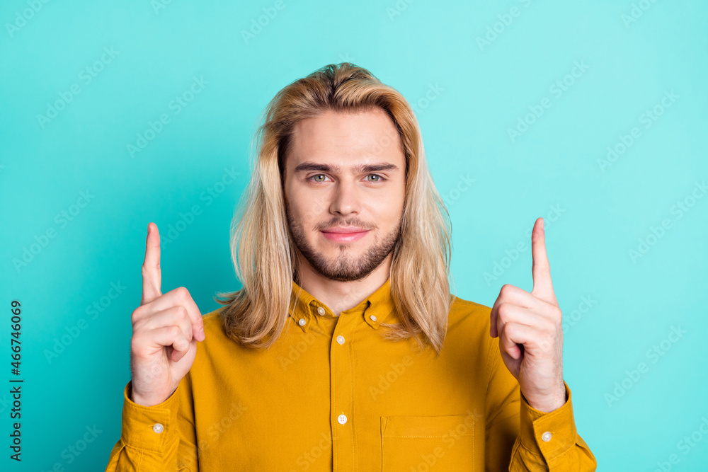 Photo of young guy happy positive smile point fingers empty space advrtisement choice isolated over teal color background Photo of young guy happy positive smile point fingers empty space advrtisement choice isolated over teal color background