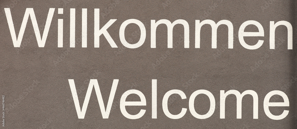 Welcome in German and English. Words on the wall. Panoramic image