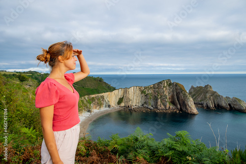 Woman contemplating coast with hand on forehead