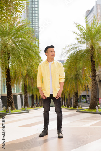Full length portrait of handsome young man outdoors in city during summer thinking © Ranta Images