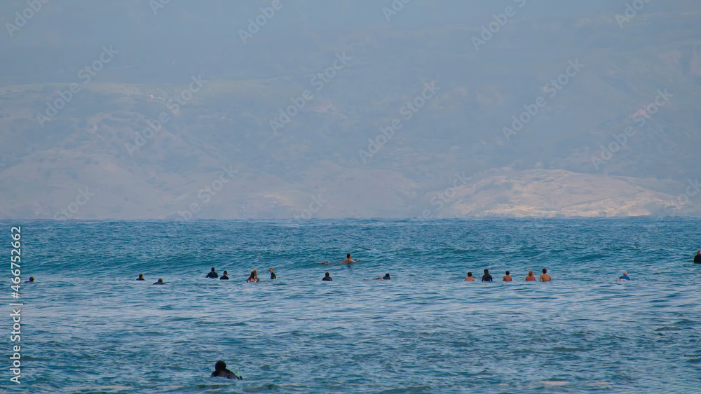 Surfers in search of a wave. Surfers in the sea are waiting for a wave.
