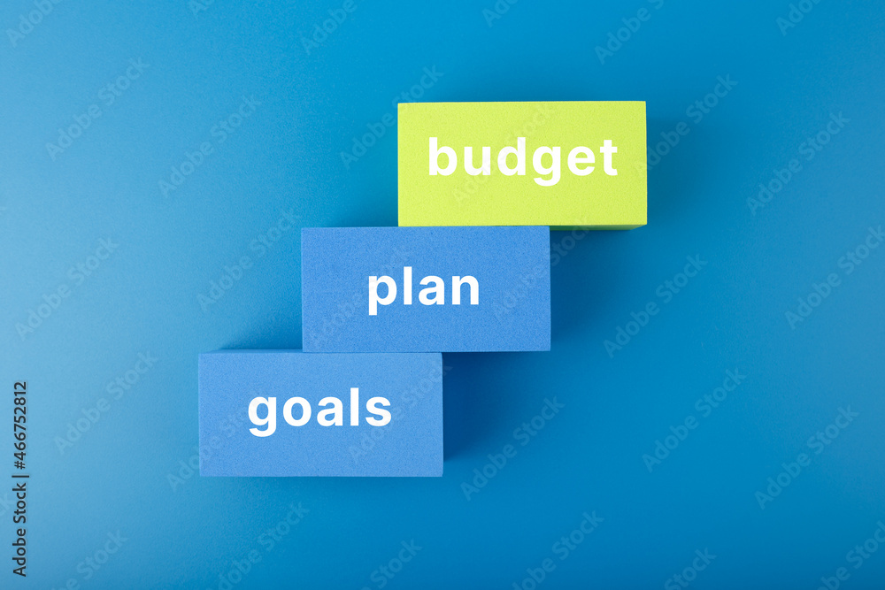 Business plan concept. Text budget, plan, goals written on colored rectangles on dark blue background