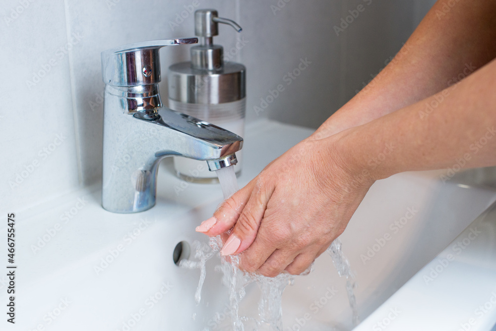 Woman use soap and washing hands rubbing with soap under the water tap. Hygiene new normal concept to stop spreading coronavirus or influenza virus.Woman use soap and washing hands under the water tap Woman use soap and washing hands rubbing with soap under the water tap. Hygiene new normal concept to stop spreading coronavirus or influenza virus.Woman use soap and washing hands under the water tap