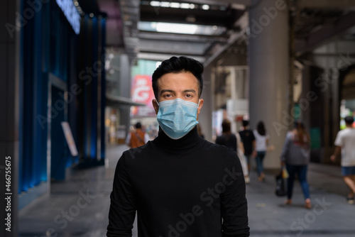 Young man outdoors in city wearing face mask