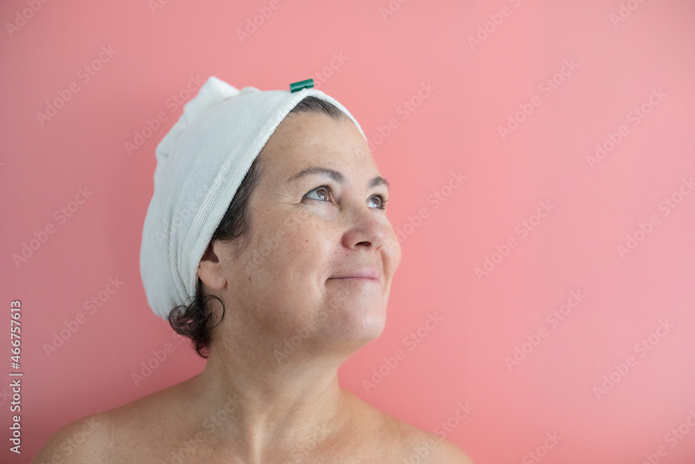 Smiling senior woman looking up in front of a pink background