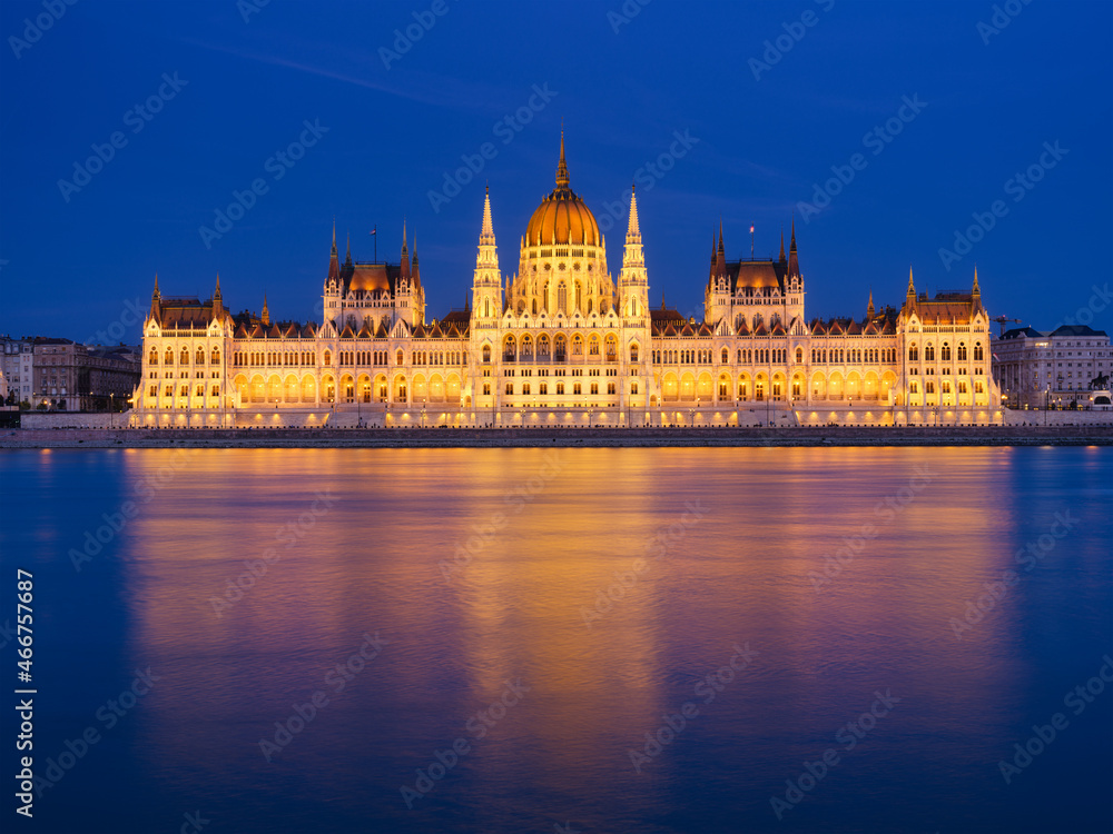 Fototapeta premium Parliament building in Budapest, Hungary. Parliament and reflections in the Danube River. Blue hour and evening illumination of the building. High resolution photo.