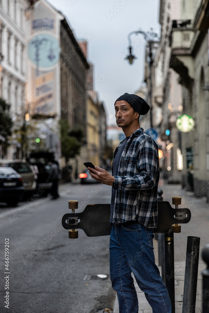 Man holding skateboard in Budapest street