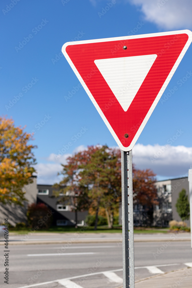 Yield give way road traffic sign on street in Ottawa, Canada in autumn