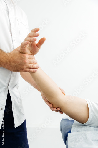 Close-up of a physiotherapist treating a patient. Osteopath holds a man's hand