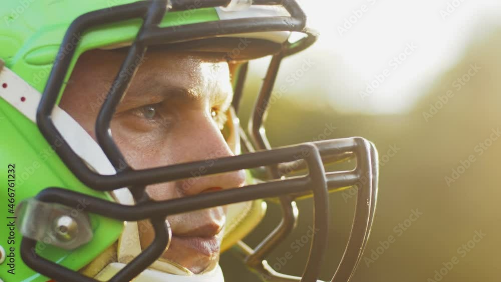 Cropped portrait of confident man in uniform and in helmet standing in the stadium ready for game. USA team game and extreme sport spirit concept Cropped portrait of confident man in uniform and in helmet standing in the stadium ready for game. USA team game and extreme sport spirit concept