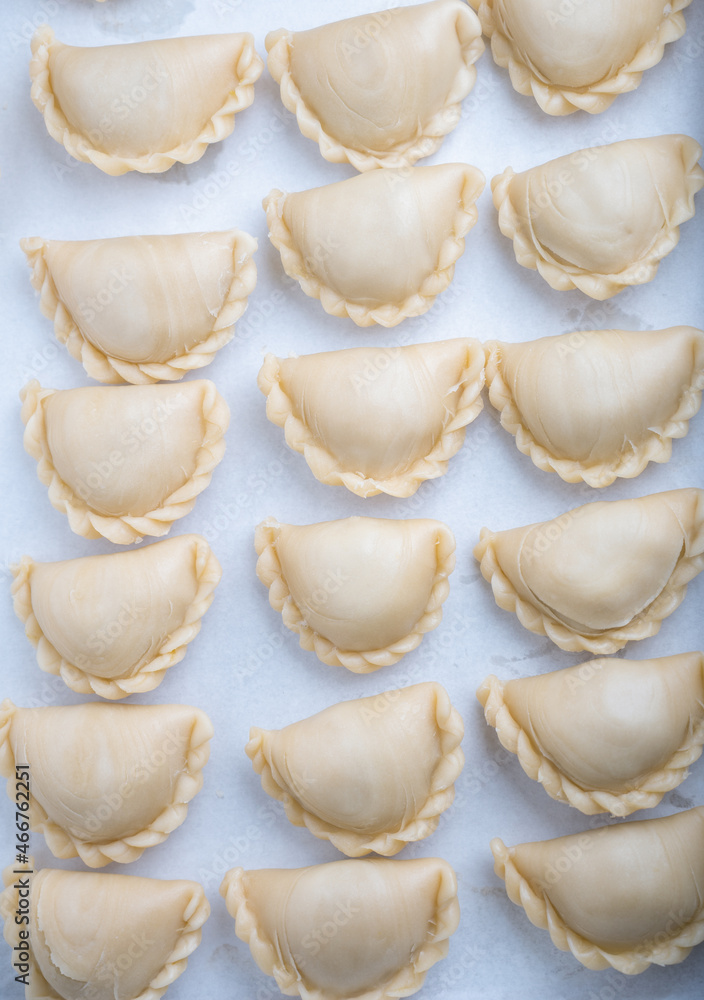 Traditional raw curry puffs stuffed chicken which are preparing for bake and frying. Traditional raw curry puffs stuffed chicken which are preparing for bake and frying.