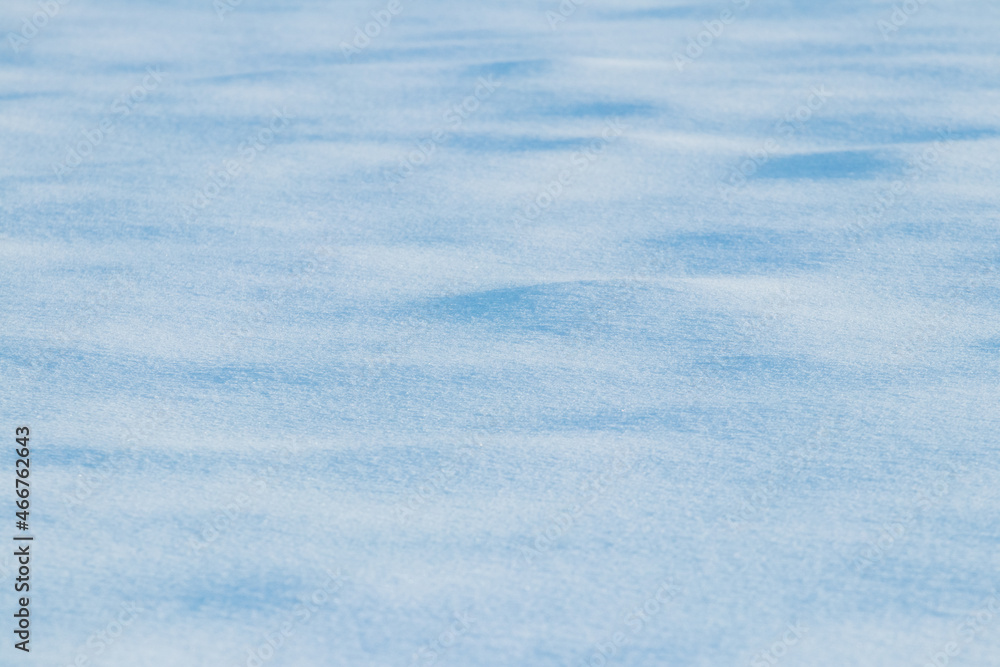 Wavy ground surface covered with snow, snow texture, winter background
