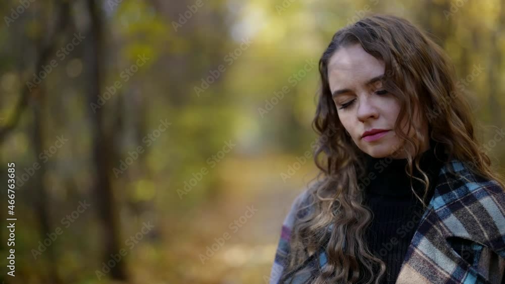 sad and melancholic woman is walking alone in forest in autumn, feeling headache sad and melancholic woman is walking alone in forest in autumn, feeling headache