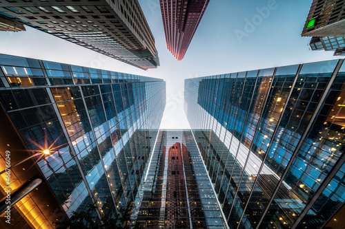 Canvas Print Looking up at high rise office buildings at sunset in the financial district of a modern metropolis, business and finance concept