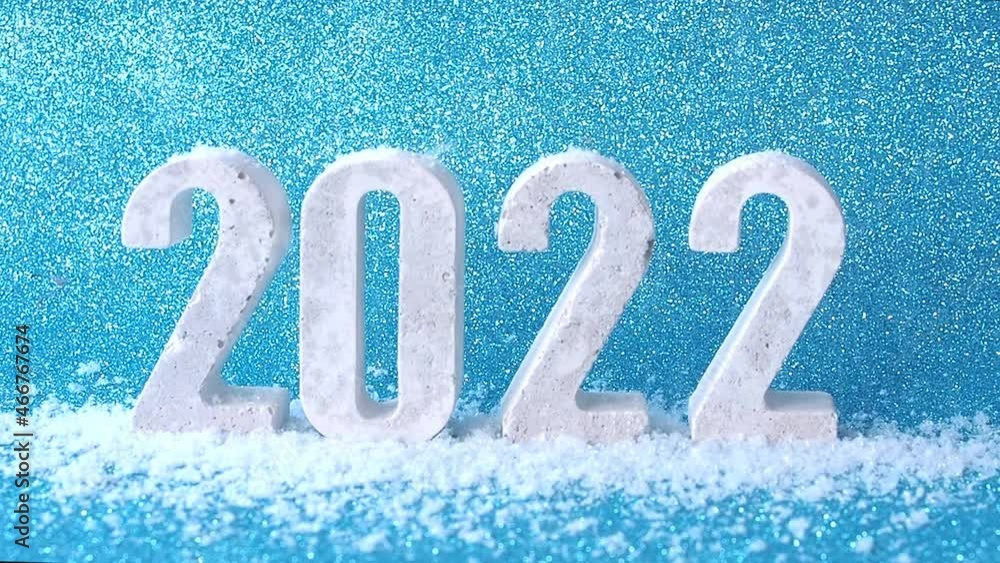 snow falls on concrete numbers 2022 on shiny blue background. snow falls on concrete numbers 2022 on shiny blue background.