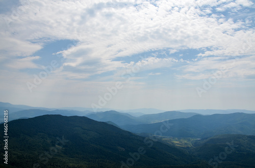 Picturesque summer landscape in Carpathian mountains. Lush green forest and cloudy sky. Travel background concept