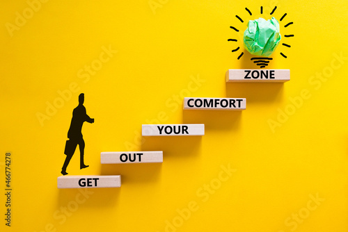 Get out your comfort zone symbol. Wooden blocks with words Get out your comfort zone on yellow background, copy space. Businessman icon, light bulb. Business, out from comfort zone concept. photo