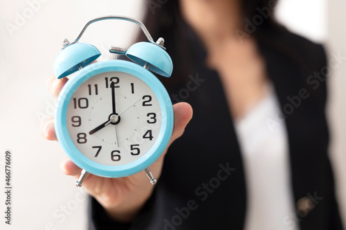 Clock in hands of business woman. return to work. working time.