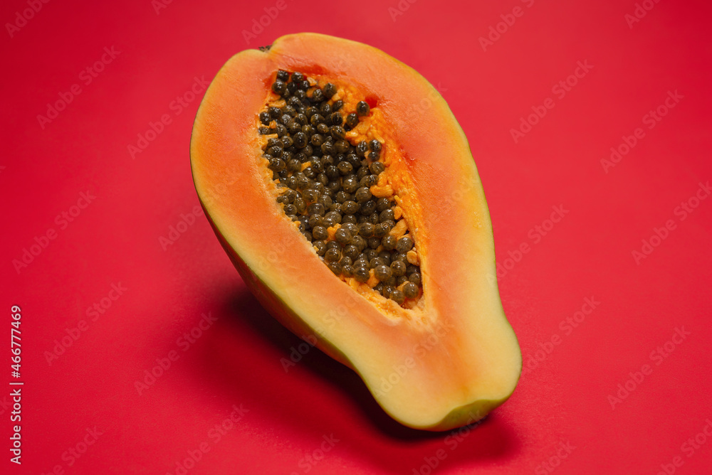 Papaya fruit on a orange background. Half papaya. Papaya fruit on a orange background. Half papaya.