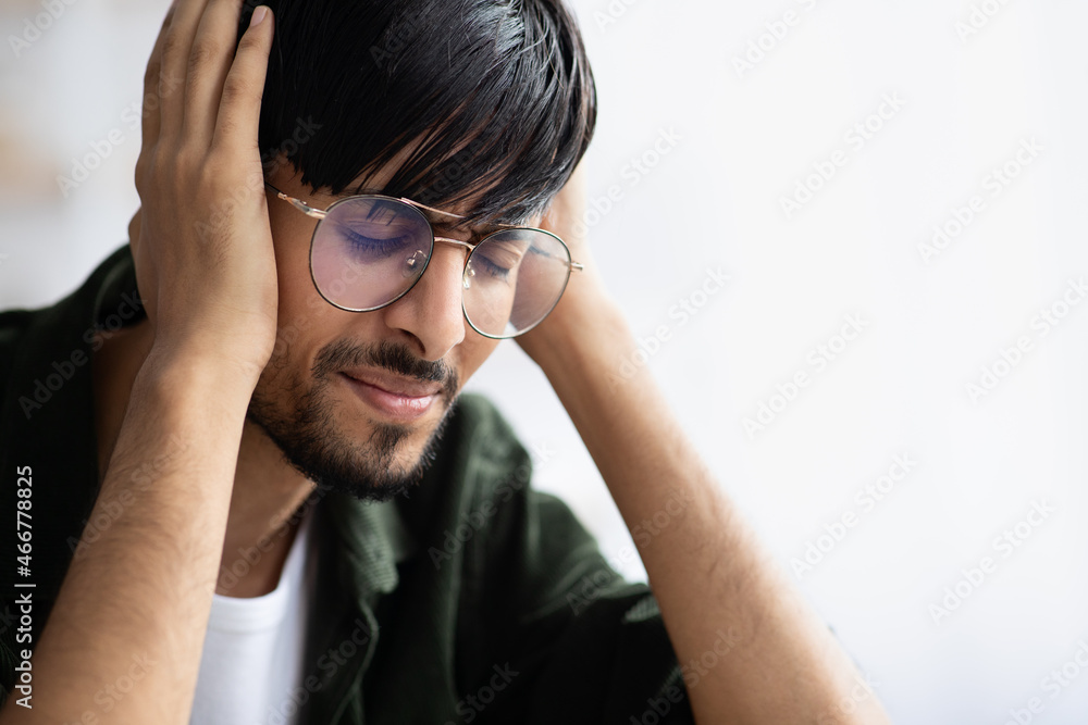 Indian guy touching his head, suffering from migraine Indian guy touching his head, suffering from migraine