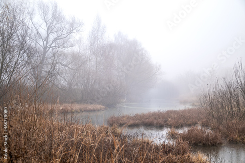 Thick fog over the bend of the riverbed in the early autumn morning