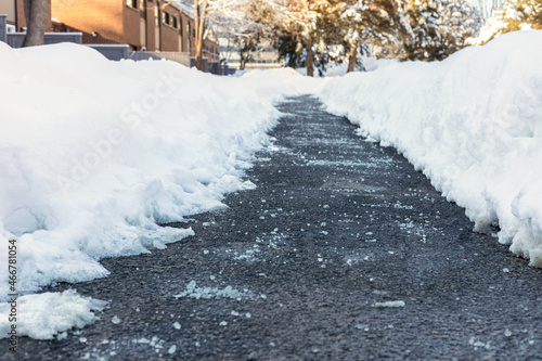 Winter road with salt for melting snow near houses