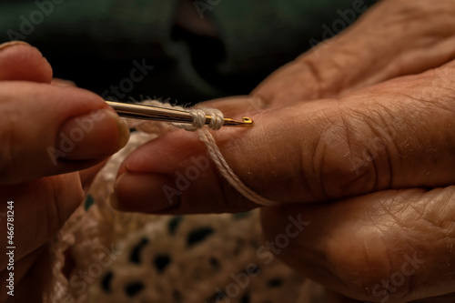 A 90-year-old lady crochets with white yarn © PLG