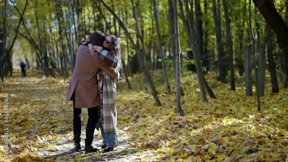 happy loving couple is embracing in park in autumn, man is holding girlfriend in hands and whirling happy loving couple is embracing in park in autumn, man is holding girlfriend in hands and whirling