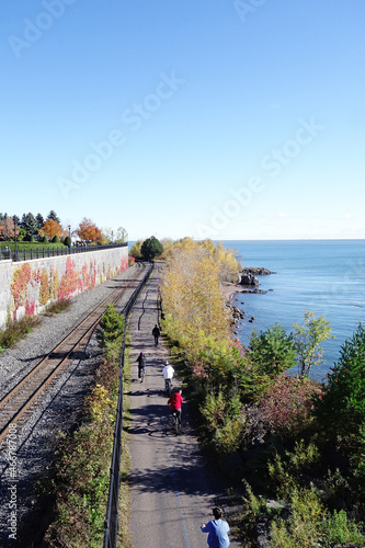 People bicycle and walk along a trail in Leif Erickson Park, along Lake Superior in Duluth Minnesota