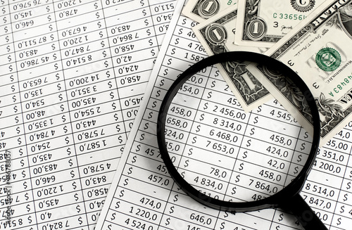 Dollars and money estimate through a magnifying glass close-up. Finance and business. Financial calculator