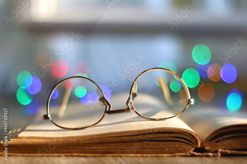 Canvas Print Open book and reading glasses on the table