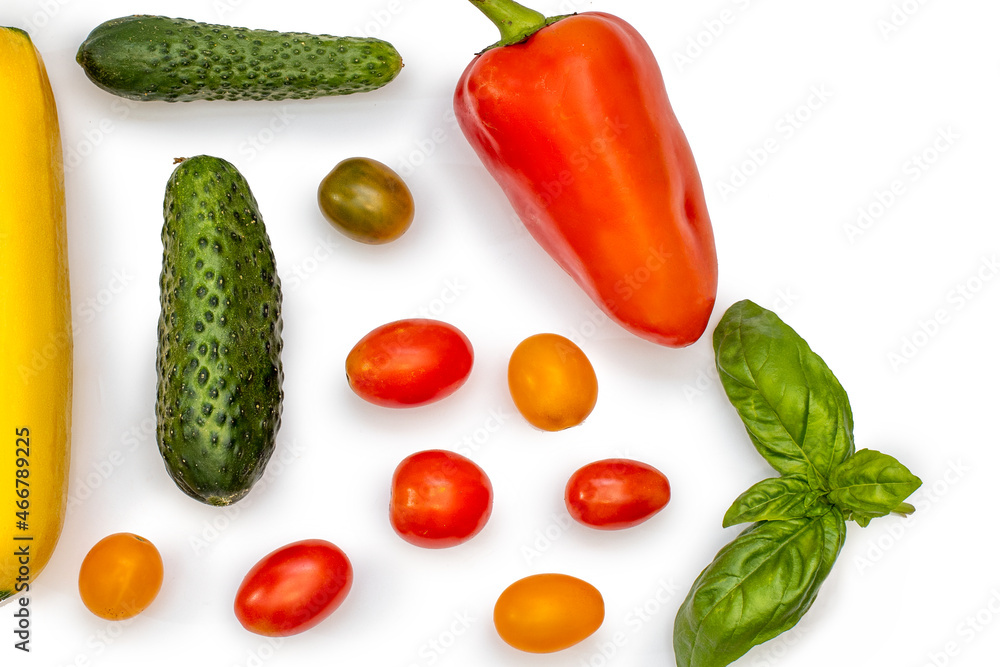 Vegetable flatlet: cucumbers, zucchini, cherry tomatoes, a sprig of basil and peppers on a white plate. Vegetable flatlet: cucumbers, zucchini, cherry tomatoes, a sprig of basil and peppers on a white plate.