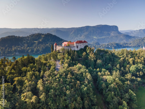 Aerial view of Blejski Grad, a beautiful castle built on top of a rock facing Lake Bled in early morning sunlight, Upper Carniola, Slovenia. photo