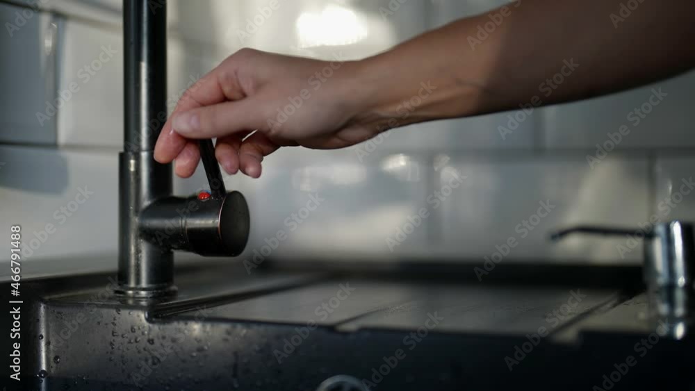 woman is opening tap with water in kitchen, slow motion shot, closeup view woman is opening tap with water in kitchen, slow motion shot, closeup view