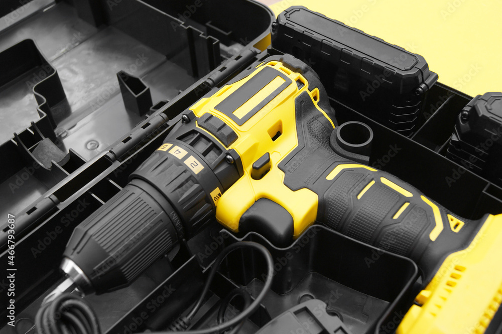 The yellow-black screwdriver on a yellow background, a set of bits. The yellow-black screwdriver on a yellow background, a set of bits.