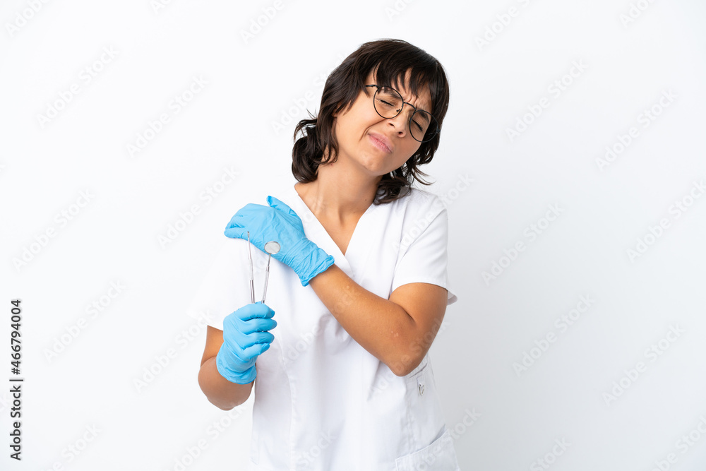 Young woman holding tools isolated on white background suffering from pain in shoulder for having made an effort Young woman holding tools isolated on white background suffering from pain in shoulder for having made an effort