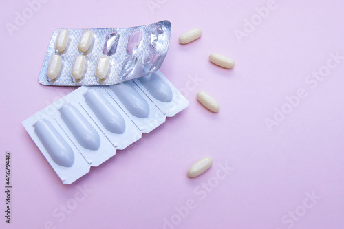 Gynecological medicines for women s health in form of suppository  capsules on pink background.