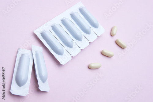 Gynecological medicines for women s health in form of suppository  capsules on pink background.