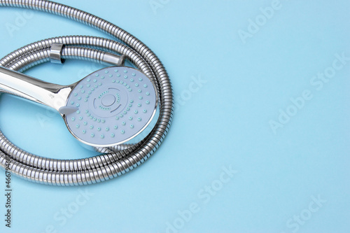 Shower head chrome coated multi-mode for the bathroom with hose on blue background.